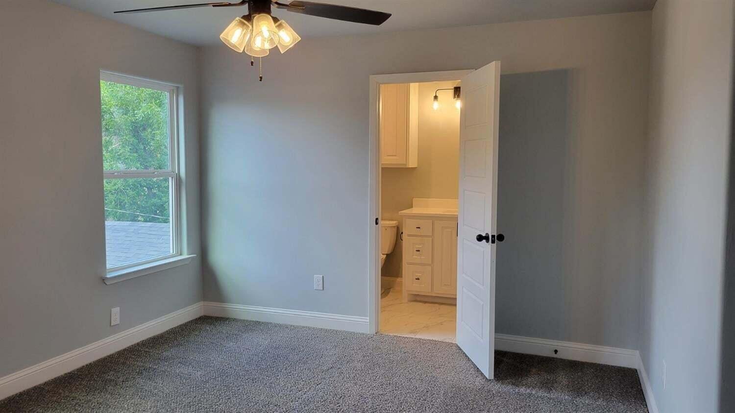 2414 25th Street Lubbock, TX 79411 - Photo 40 of 61 an empty room that has a chandelier fan and a window