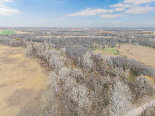a view of a dry yard with wooden fence