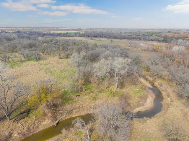 a view of a dry yard with wooden fence