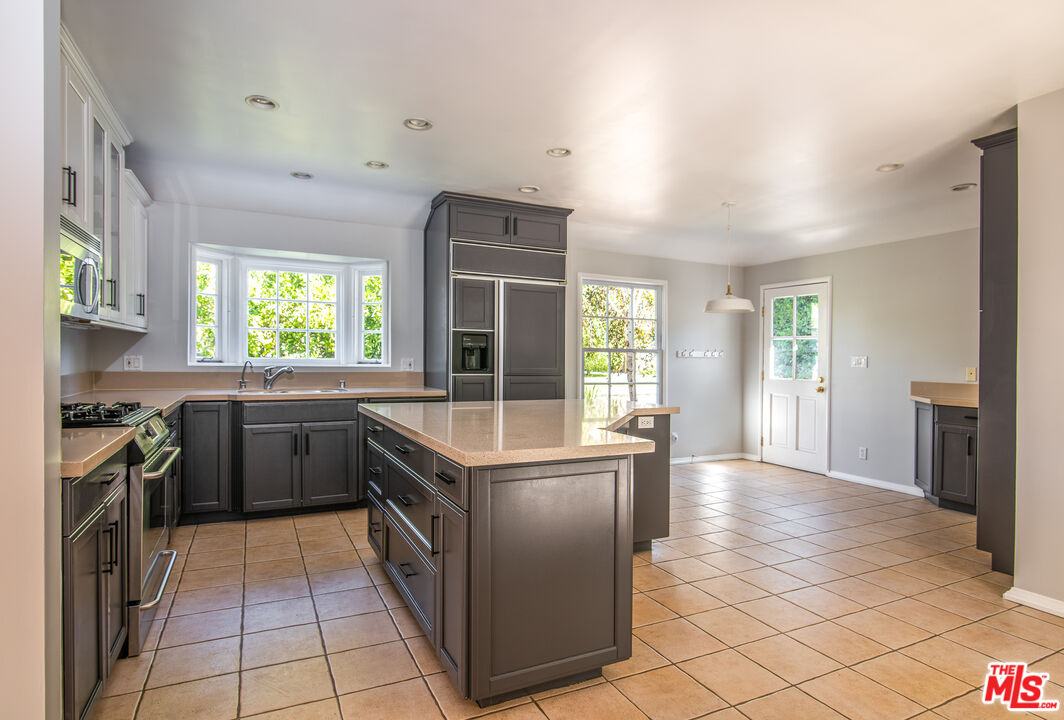 11144 Valley Spring Place Studio City, CA 91602 - Photo 11 of 36 a kitchen with stainless steel appliances granite countertop a stove and a sink