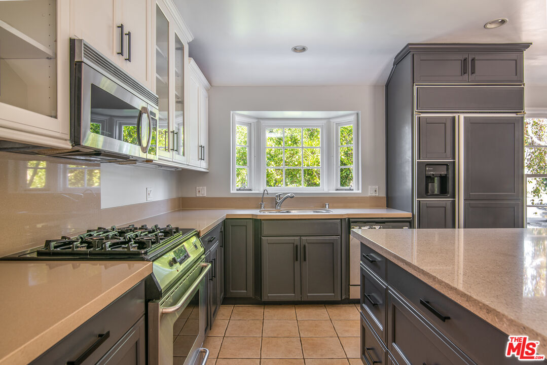 11144 Valley Spring Place Studio City, CA 91602 - Photo 12 of 36 a kitchen with stainless steel appliances granite countertop a sink and a stove