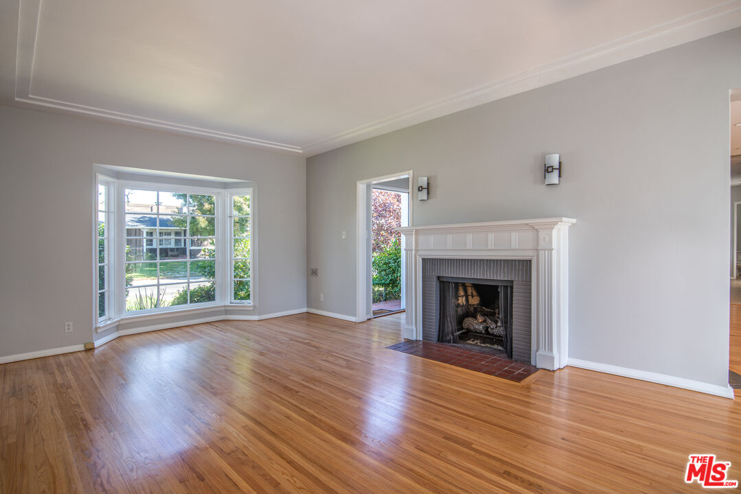 11144 Valley Spring Place Studio City, CA 91602 - Photo 6 of 36 a view of an empty room with wooden floor fireplace and a window