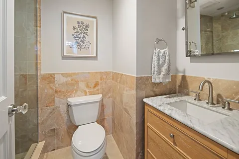 a bathroom with a granite countertop toilet sink and mirror