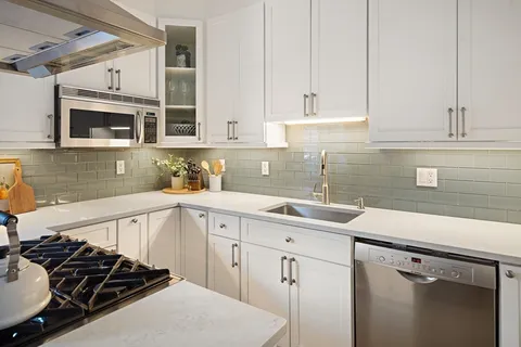 a kitchen with stainless steel appliances a sink stove and cabinets