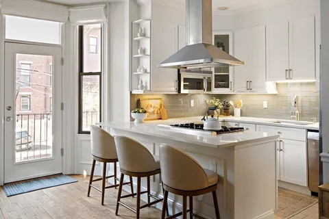 a kitchen with stainless steel appliances granite countertop a stove a table and chairs