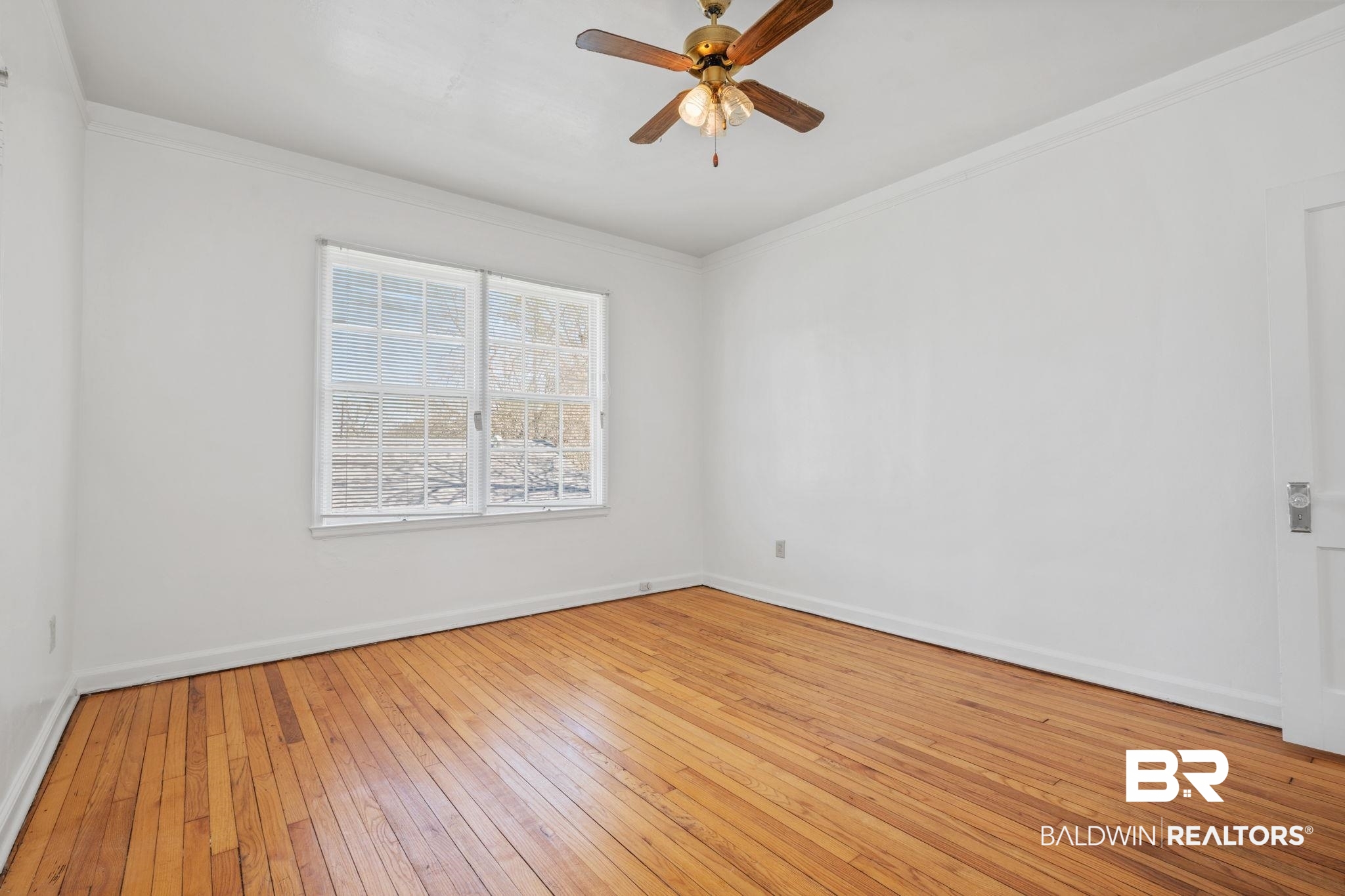 1707 Church Street Mobile, AL 36604 - Photo 29 of 43 Empty room featuring a ceiling fan, light wood-type flooring, baseboards, and ornamental molding