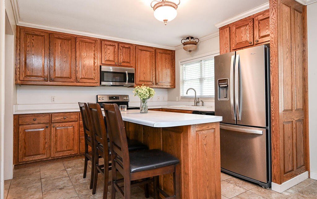 5024 Spring Place Road Southeast Cleveland, TN 37323 - Photo 14 of 43 a kitchen with stainless steel appliances granite countertop a refrigerator a stove a sink a dining table and chairs with wooden floor