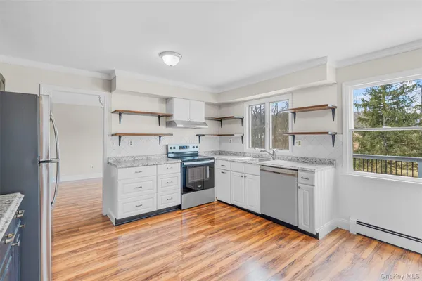 a kitchen with granite countertop cabinets stainless steel appliances a sink and a window