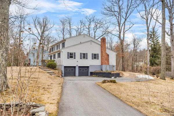 a view of white house with a snow on the road