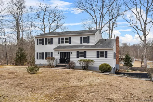 a front view of a house with a yard covered with snow in front of house
