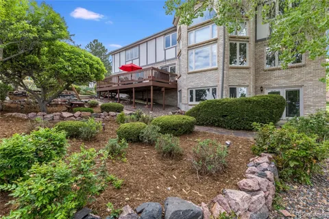 a view of a brick house with a yard and plants