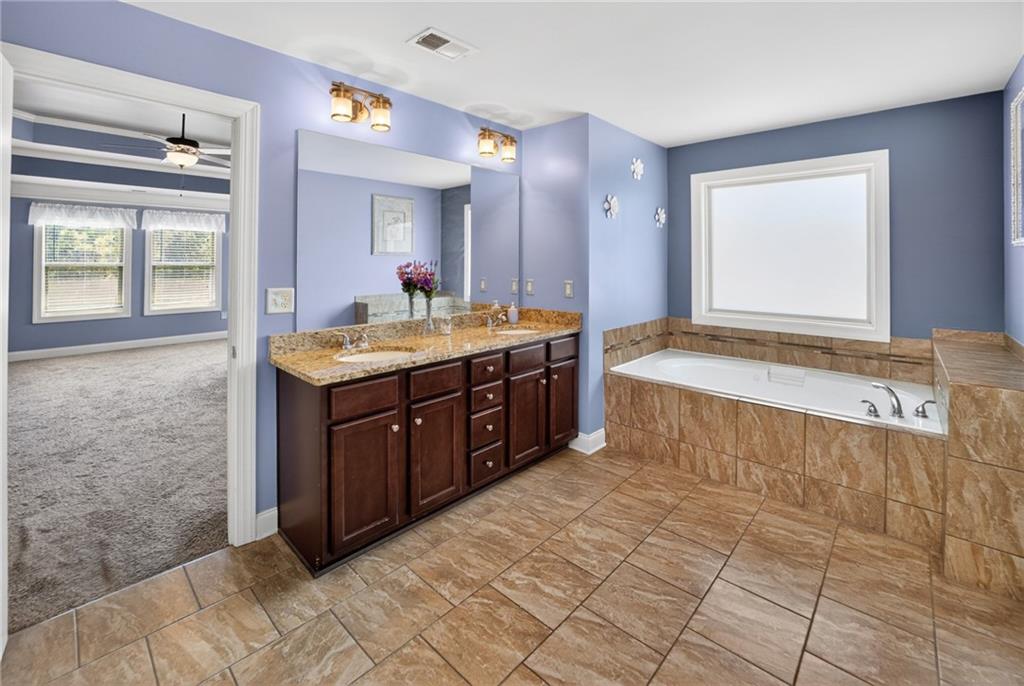 2300 Tucker Mill Road Southwest Conyers, GA 30094 - Photo 22 of 45 a spacious bathroom with a tub sink and mirror
