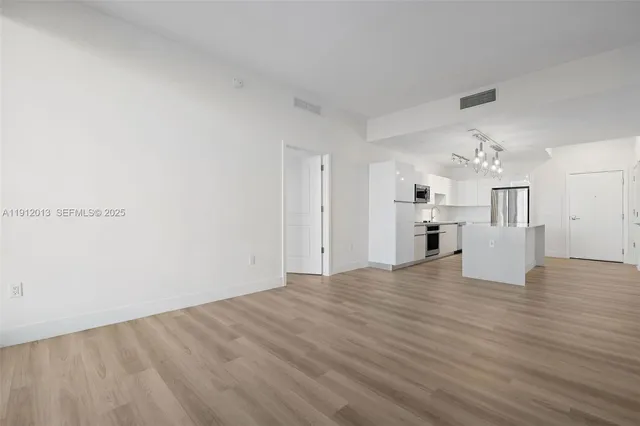 a view of a hallway with wooden floor and closet