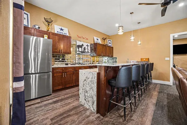 a kitchen with stainless steel appliances a refrigerator a table and chairs