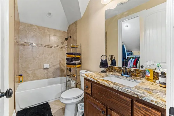 a bathroom with a granite countertop sink toilet and shower