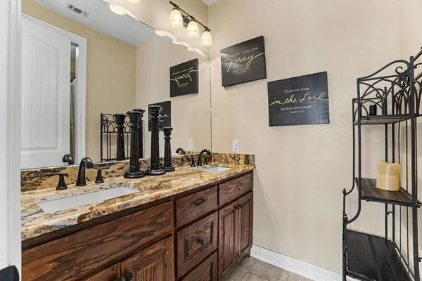 a bathroom with double vanity sink and a mirror