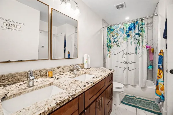a bathroom with a sink a toilet and a shower curtain