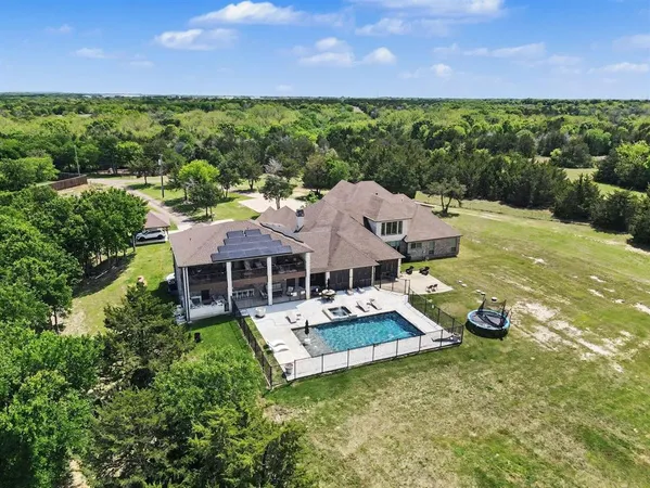 a aerial view of a house with swimming pool and a yard
