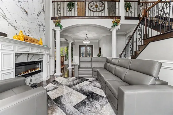 a living room with furniture a fireplace and a chandelier