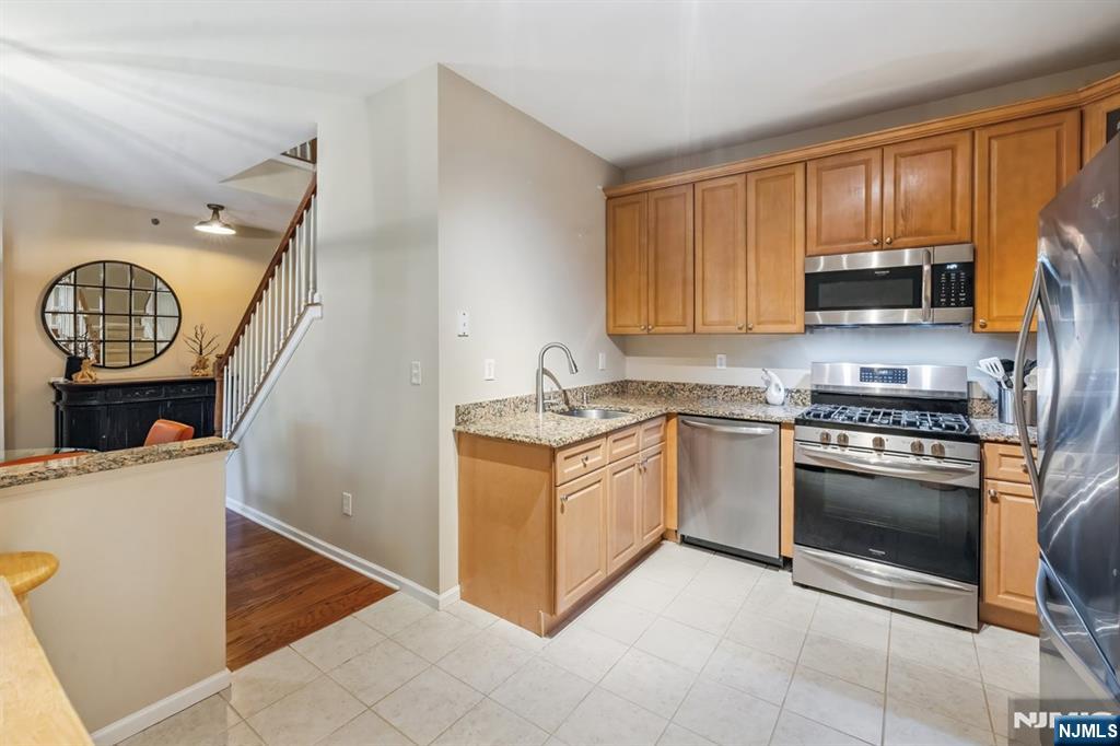 175 Rochelle Avenue, Unit 321 Rochelle Park, NJ 07662 - Photo 20 of 27 a kitchen with granite countertop a stove a sink and a microwave