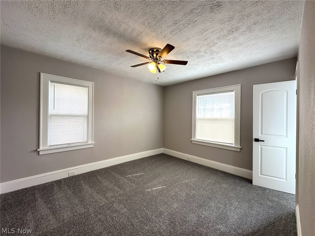 3409 Cedarbrook Road Cleveland Heights, OH 44118 - Photo 12 of 16 Spare room with dark colored carpet, a ceiling fan, and a textured ceiling