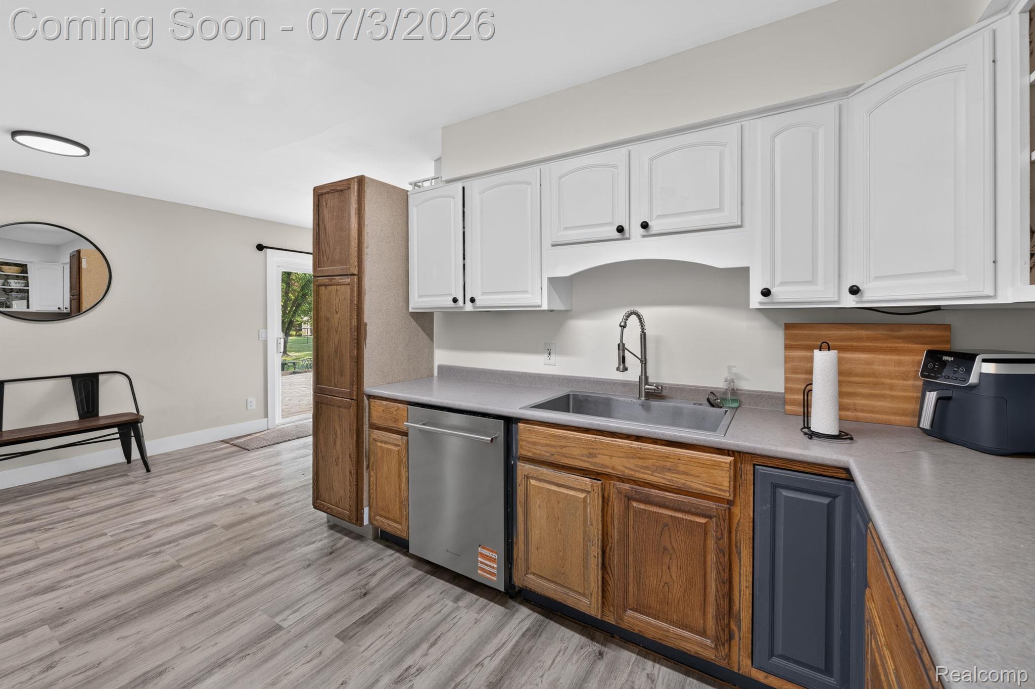5355 North Seymour Road Flushing, MI 48433 - Photo 12 of 41 Kitchen featuring white upper cabinetry, wood-finish lower cabinetry, and a stainless steel sink with a gooseneck faucet