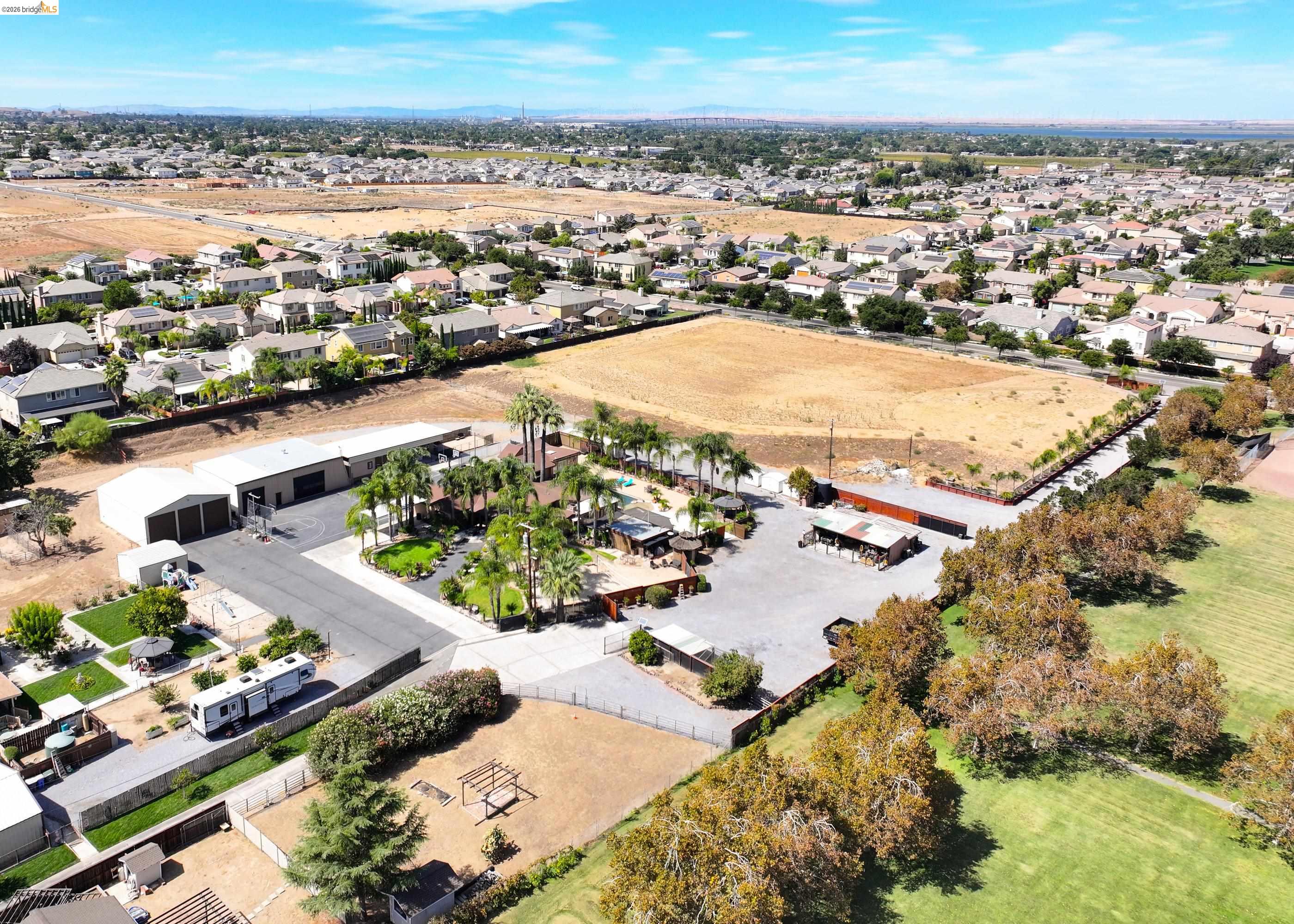 340 West Bolton Road Oakley, CA 94561 - Photo 2 of 87 Expansive property featuring multiple outbuildings, mature palm trees, and a paved drive