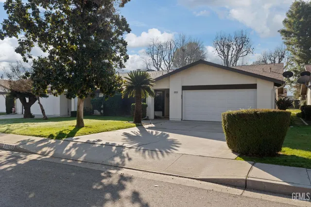 a view of a house with a yard and tree