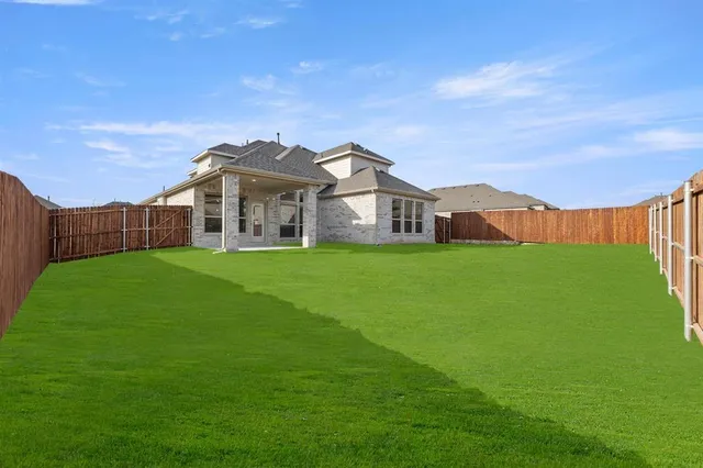 a view of a house with a big yard and large trees