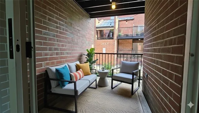 a view of a balcony with furniture and a potted plant