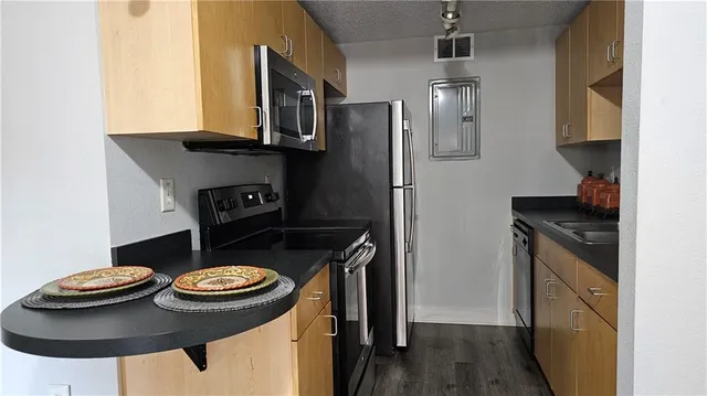 a kitchen with stainless steel appliances granite countertop a sink stove and refrigerator