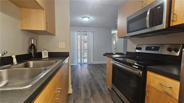 a kitchen with stainless steel appliances granite countertop a sink stove and microwave