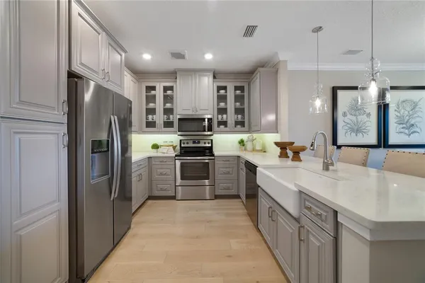 a large kitchen with a refrigerator a stove top oven a sink and dishwasher