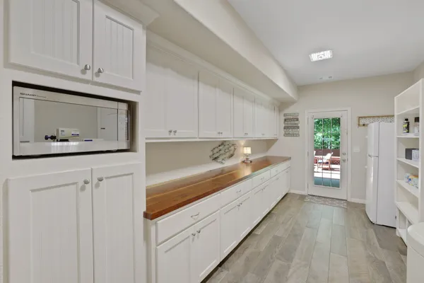 a large white kitchen with stainless steel appliances granite countertop a stove a microwave and a refrigerator