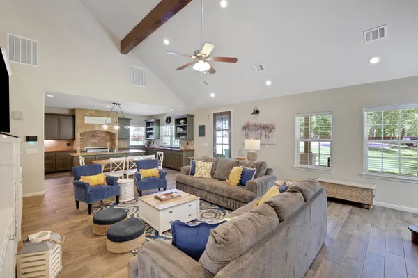 a living room with furniture kitchen view and a large window
