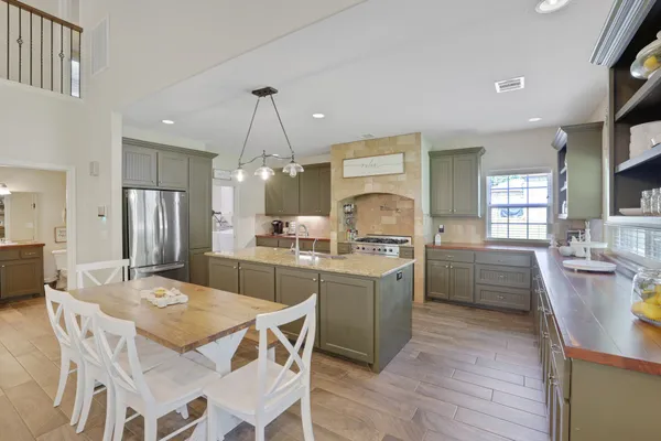 a kitchen with a dining table chairs wooden floor and appliances