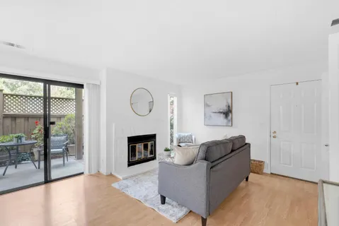 a living room with furniture a large window and a fireplace
