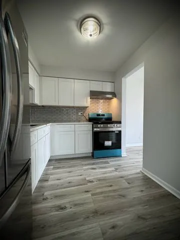 a view of empty room with wooden floor and window