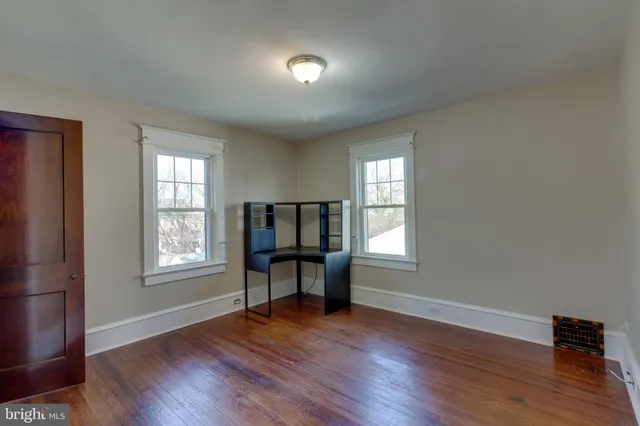 an empty room with windows and wooden floor