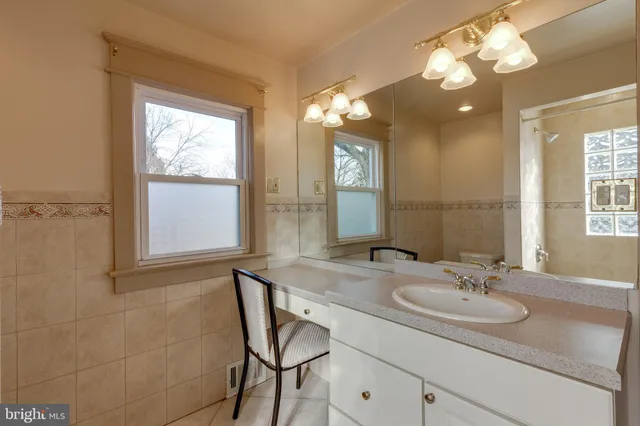 a bathroom with a granite countertop sink a light fixture and a mirror
