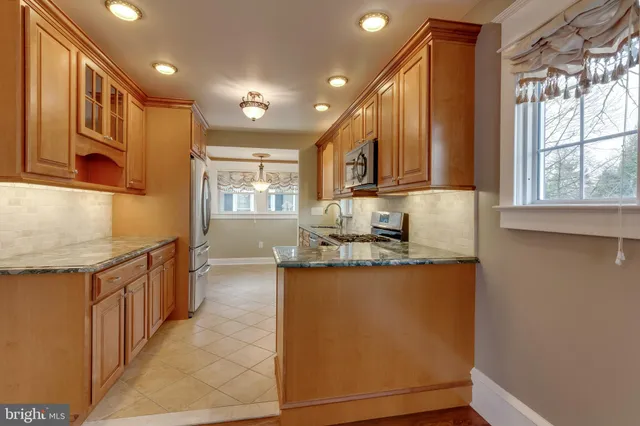 a kitchen with stainless steel appliances granite countertop a sink a stove and a refrigerator