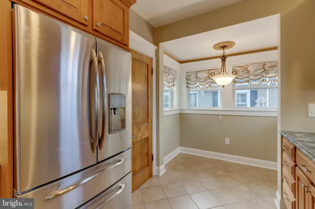 a view of a refrigerator in kitchen and a windows