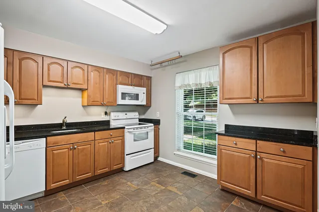 a kitchen with cabinets appliances a sink and a window