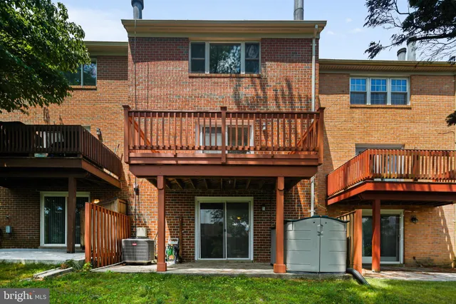 a view of a house with brick walls and a yard with plants