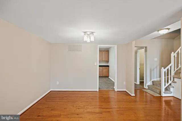 a view of empty room with wooden floor