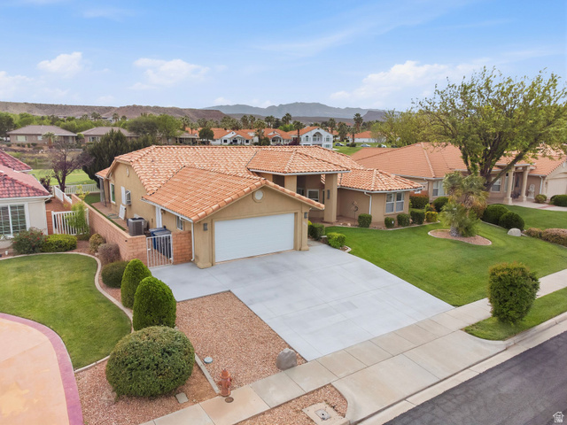 1985 West Rivers Edge Lane St. George, UT 84770 - Photo 4 of 42 Mediterranean / spanish-style home featuring a residential view, stucco siding, an attached garage, and driveway