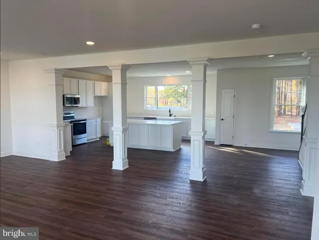 an empty room with wooden floor and fireplace
