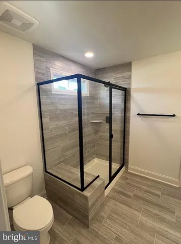 a bathroom with a toilet and a shower