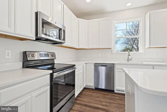 a kitchen with cabinets appliances and a sink
