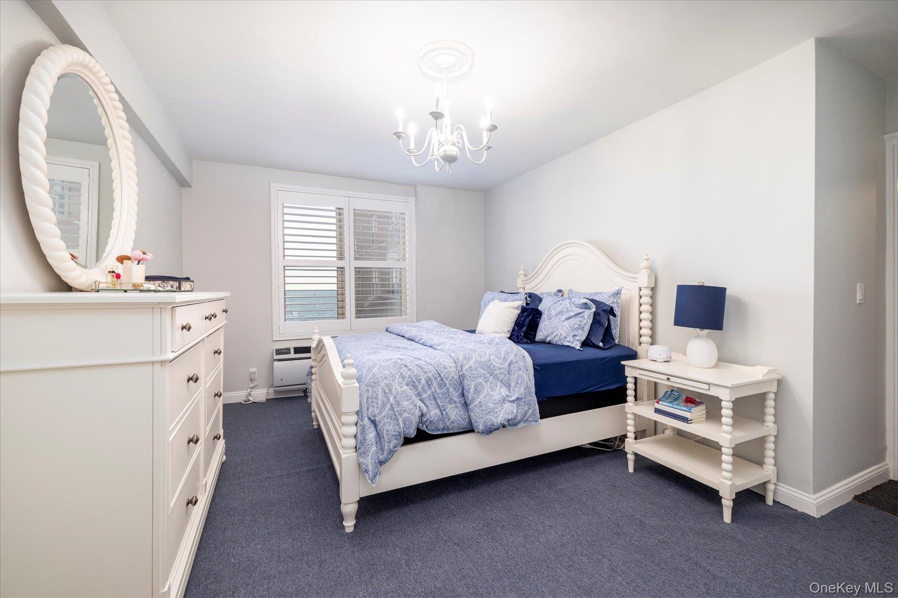 560 West Broadway, Unit 4R Long Beach, NY 11561 - Photo 15 of 26 a spacious bedroom with a bed and a chandelier